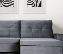 A imagem mostra uma sala de estar com um sofá retrátil na cor cinza linkando para a coleção Retráteis e Reclináveis